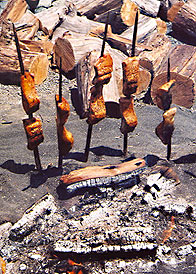 salmon cooking on sticks